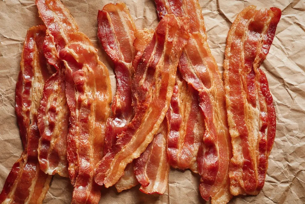 Sütőpapírral bélelt tepsiben, 200 fokon zsírszag nélkül ropogósra sül a bacon, pár perc alatt! (Fotó: Shutterstock)