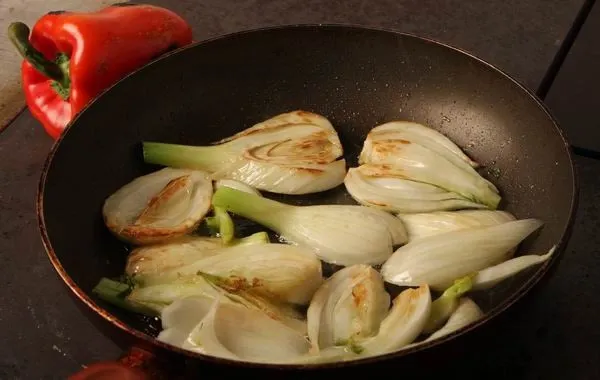 Sül az édeskömény a serpenyőben, a platnin a paprika