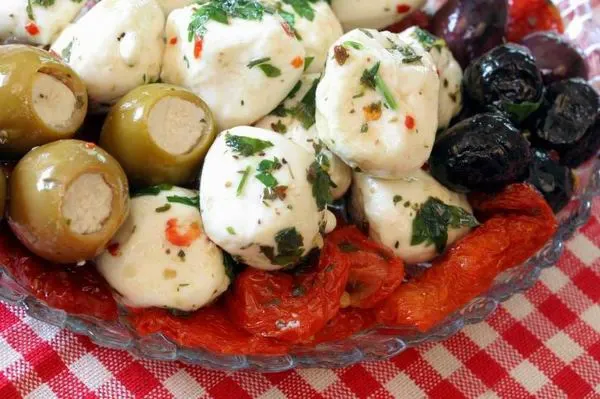 A friss fűszerekkel pácolt mini mozzarella olívabogyókkal tálalva tökéletes előétel