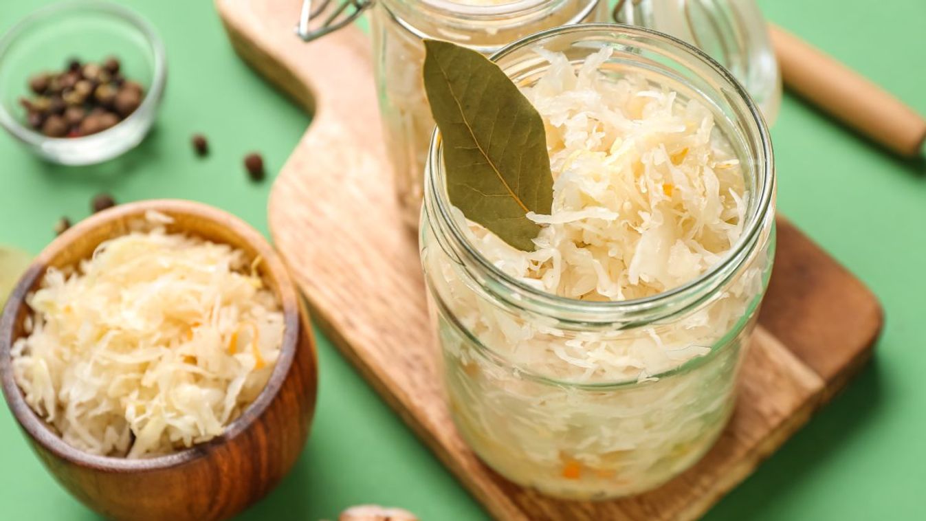 Jars,And,Bowl,Of,Tasty,Sauerkraut,With,Ingredients,On,Green