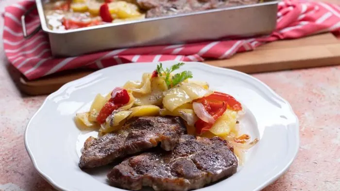 Tepsis tarja vele sült burgonyával, együtt sül a köret és a hús a mennyei ebédben