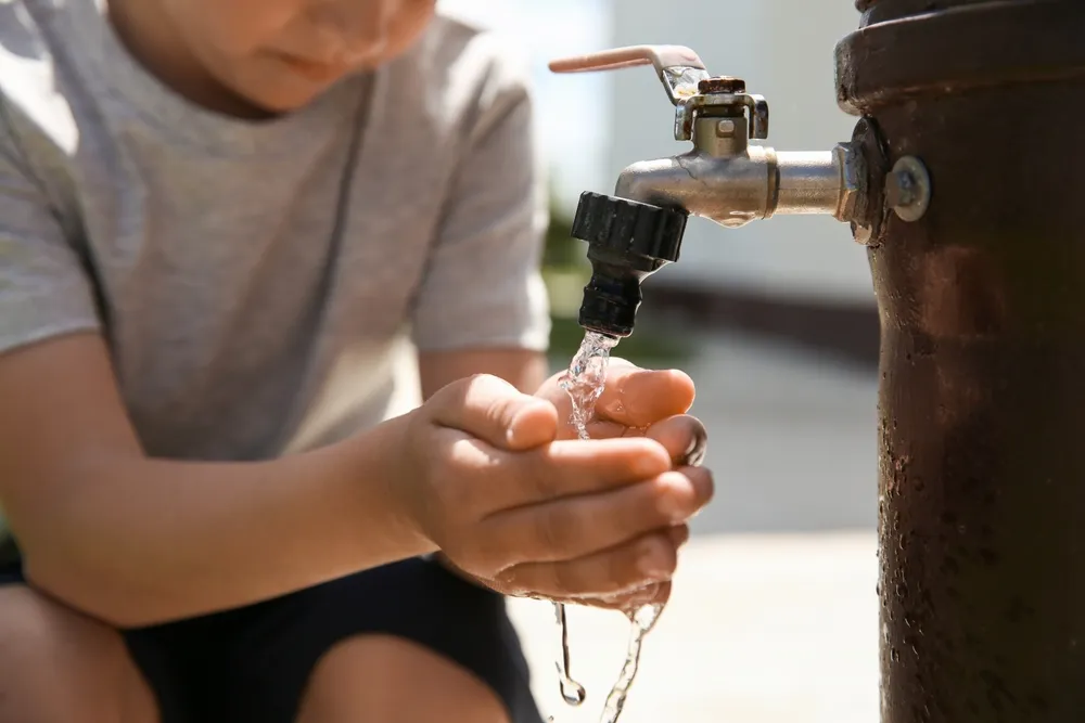 Water,Scarcity.,Little,Boy,Drinking,Water,From,Tap,Outdoors,,Closeup