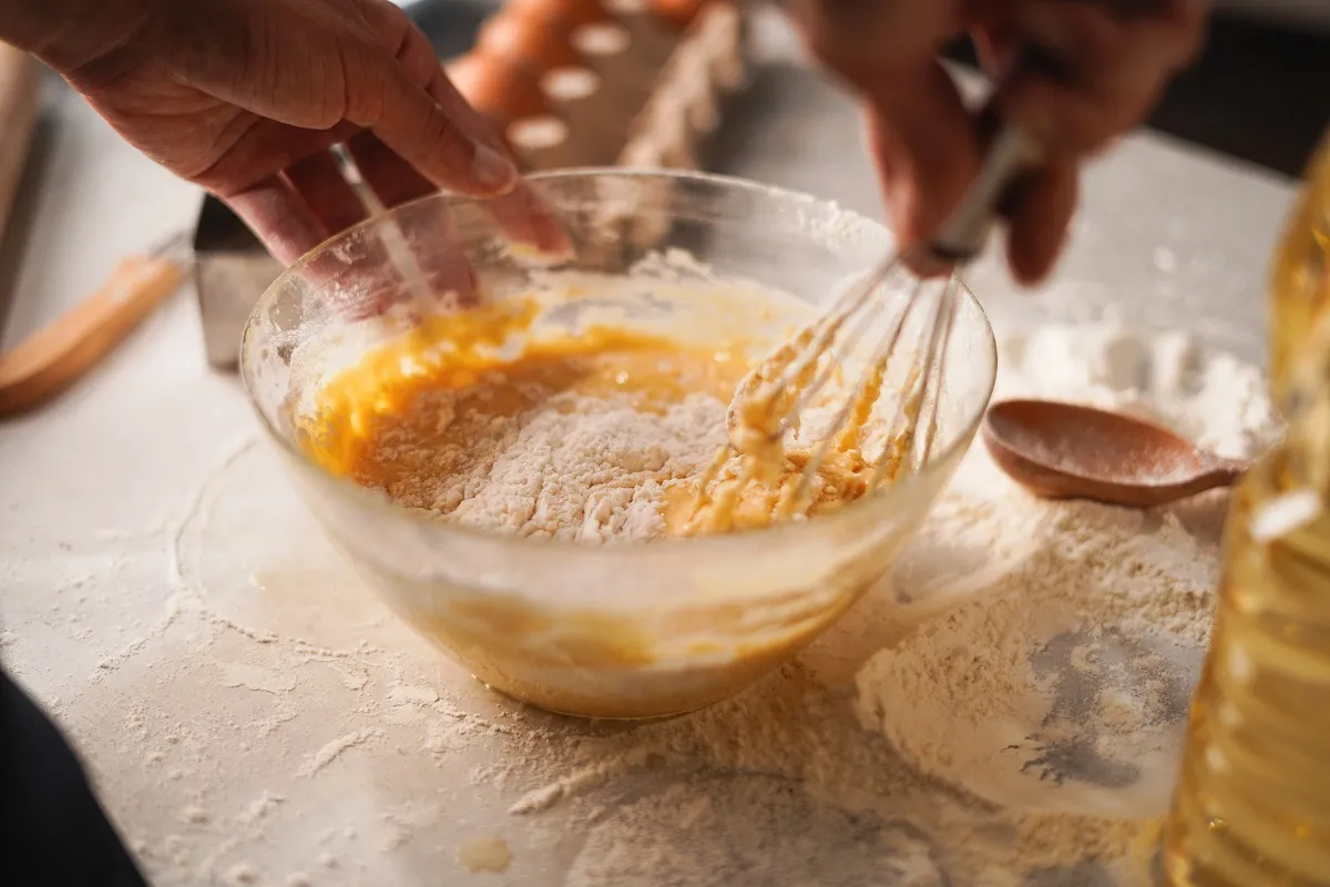 Close-up,Of,Hands,Whisking,Flour,And,Eggs,In,Bowl,During