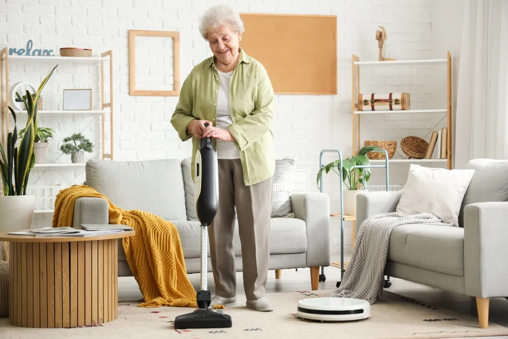 Happy,Senior,Woman,With,Vacuum,Cleaner,And,Robot,Vacuum,Cleaner