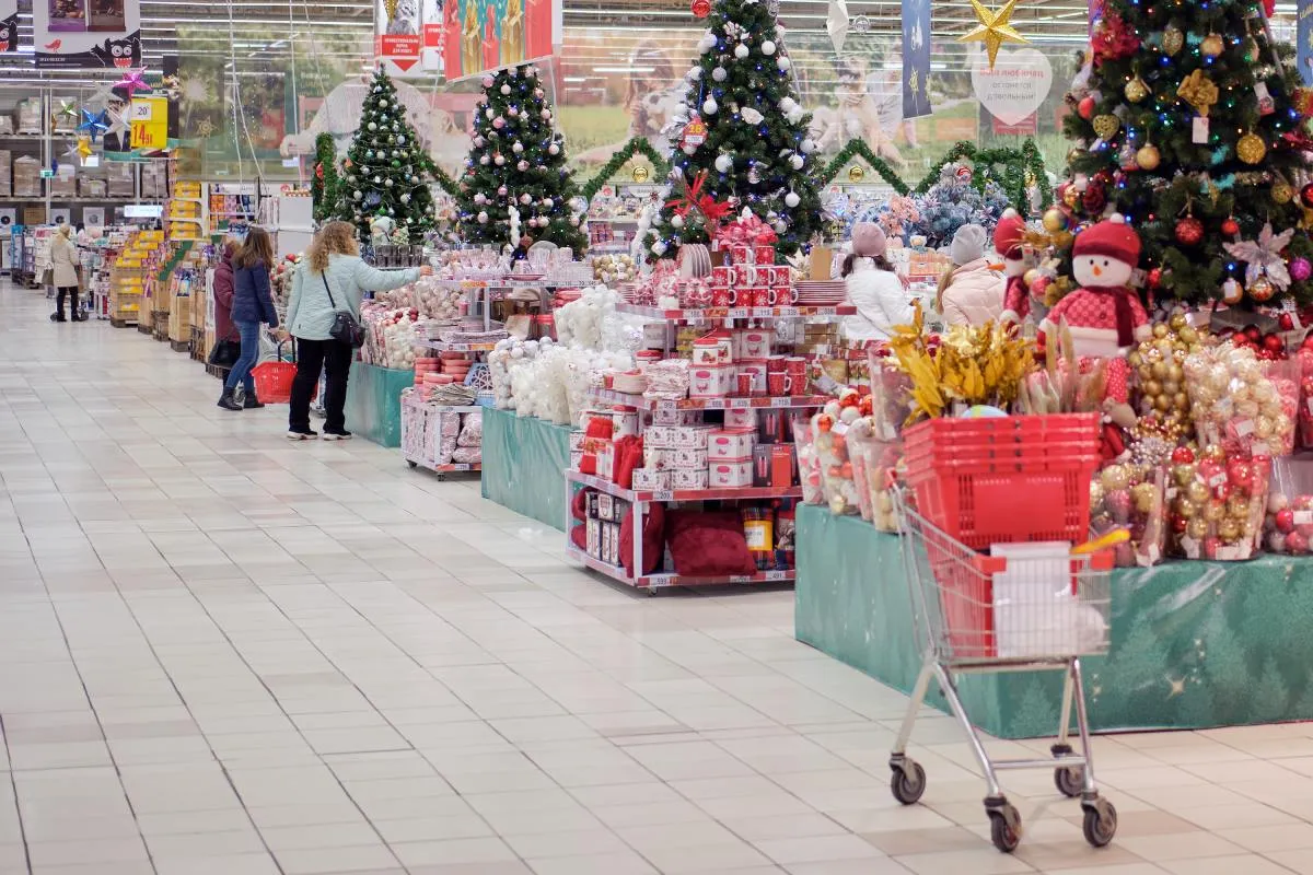 Auchan áruházban karácsonyi díszek, dekorációk között vásárlók válogatnak