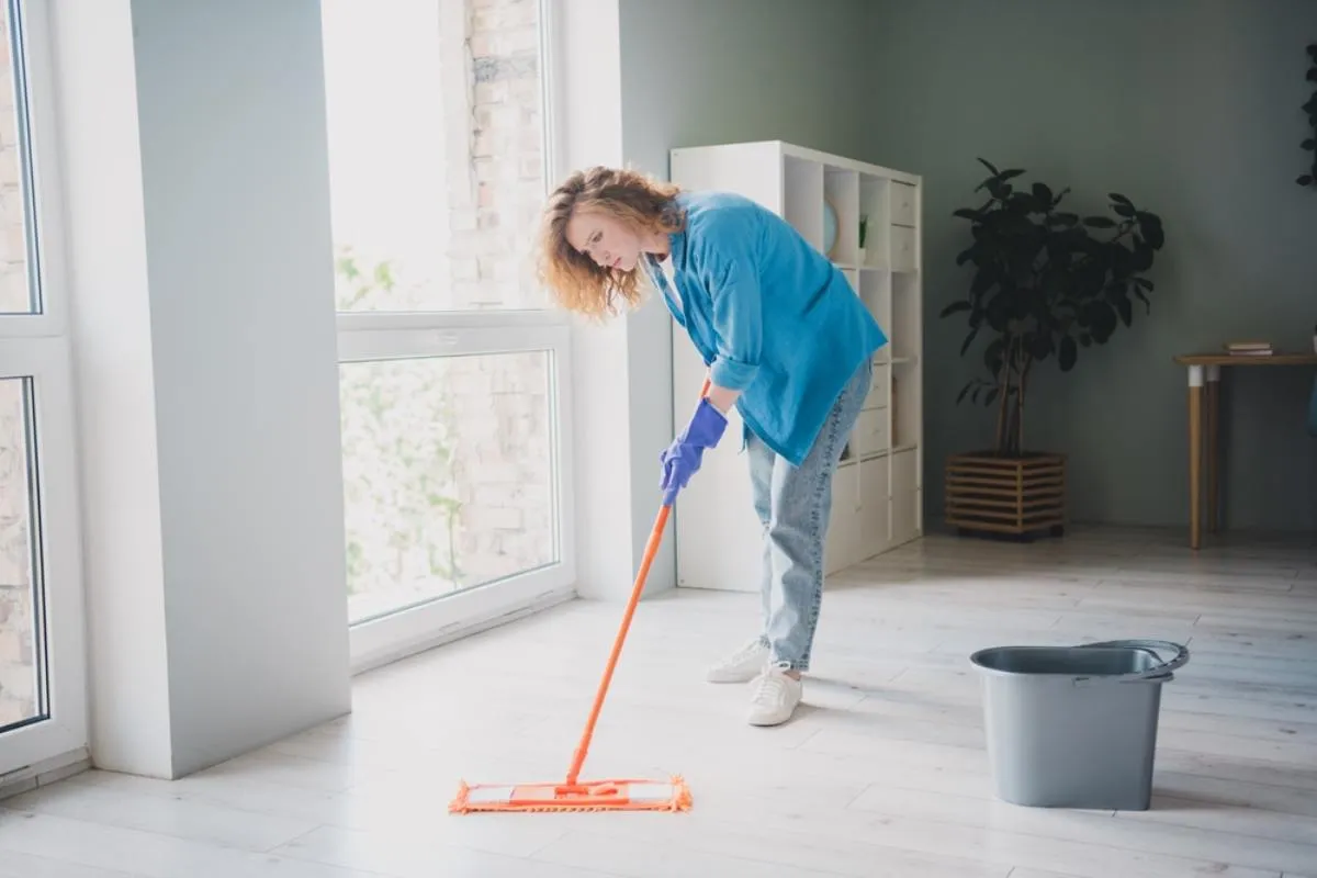 Felmosás: egy nő világos szobában felmos