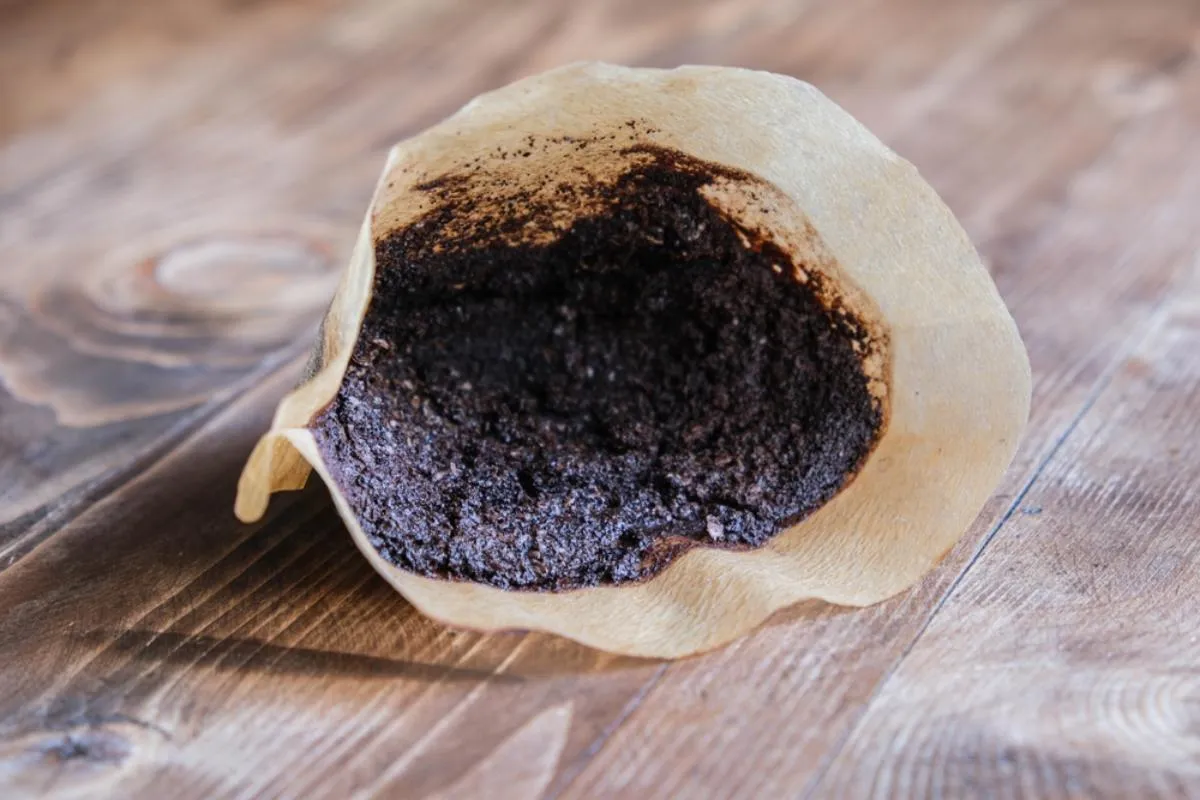 Kávézacc egy kávéfilterben, ami az asztalon hever