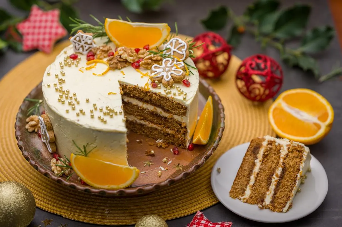 Narancsos mézeskalácstorta: karácsonyi díszekkel gyönyörű torta, amin dió, apró mézeskalács-figurák és narancskarikák vannak
