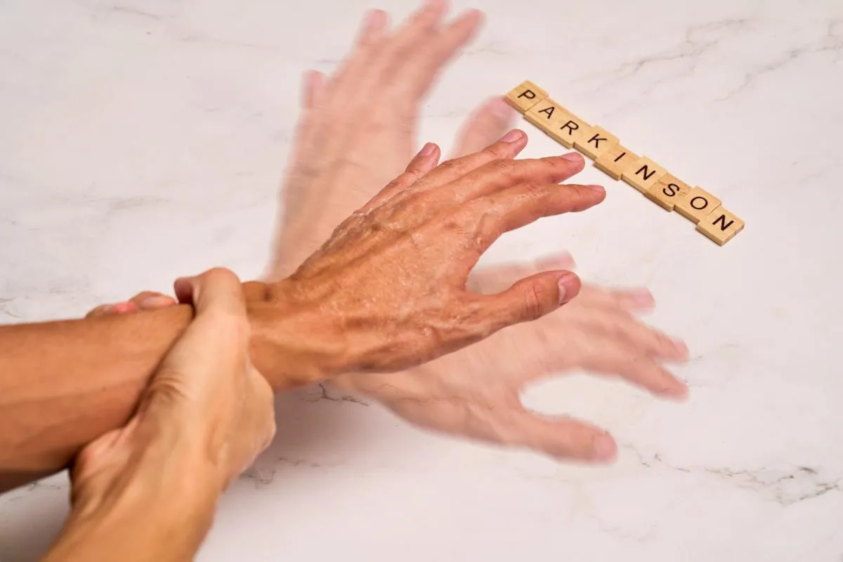 Parkinson-kór: remegő kezét fogja a másik kezével egy férif