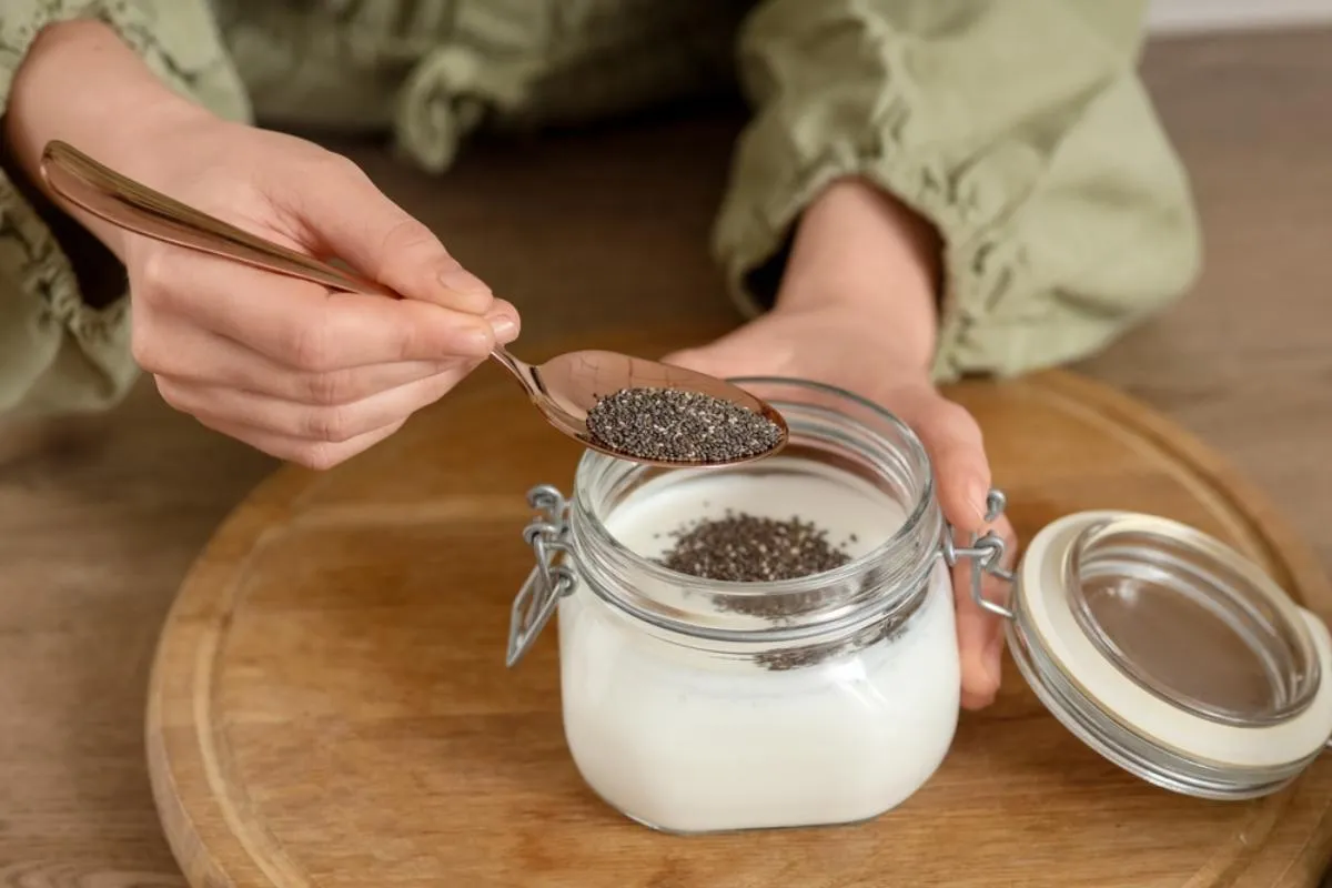 A chia mag étvágycsökkentő hatása ismert - egy nő joghurtba kanalaz ciha magot