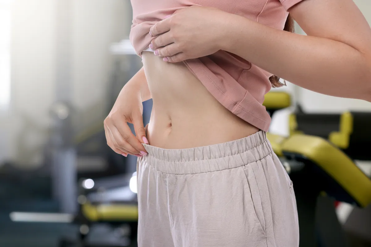 Az edzőteremben a nő a lapos has elérésén dolgozik