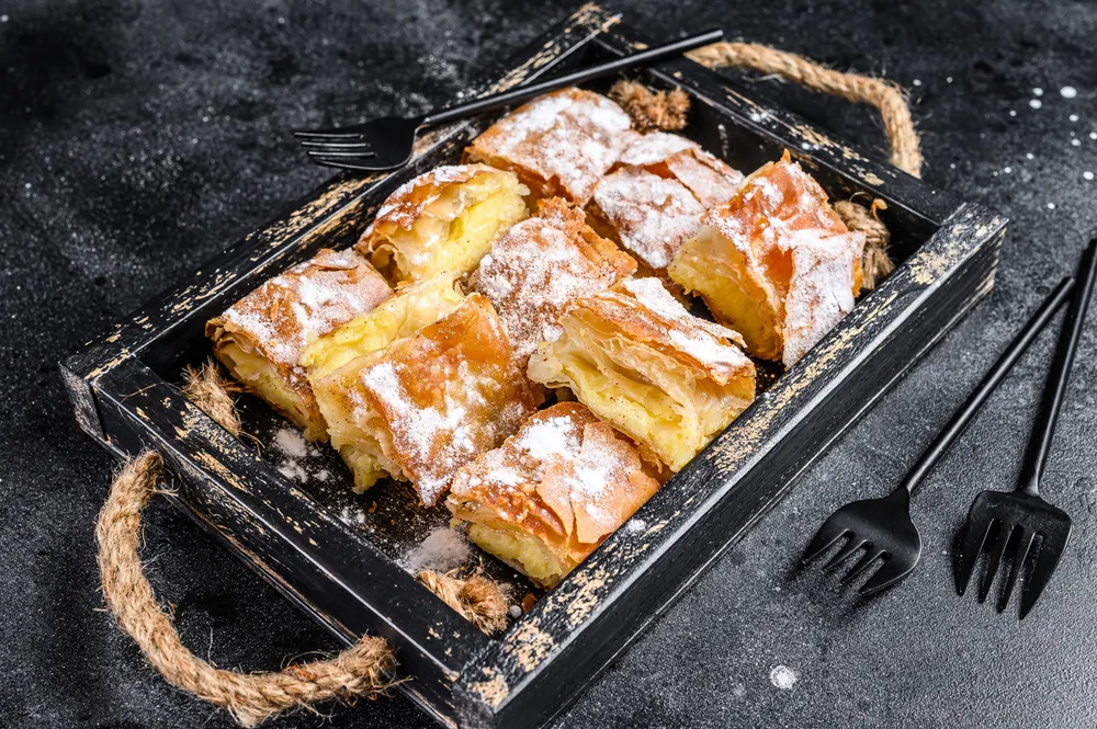 Sliced,Bougatsa,Pie,Pastry,With,Semolina,Custard,Cream.,Black,Background.