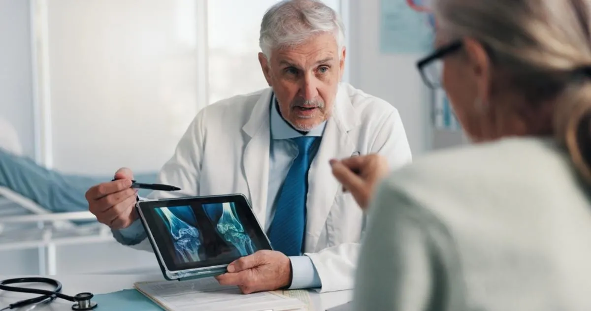 Osteopenia: csontról készült felvételeket mutat egy orvos a betegének