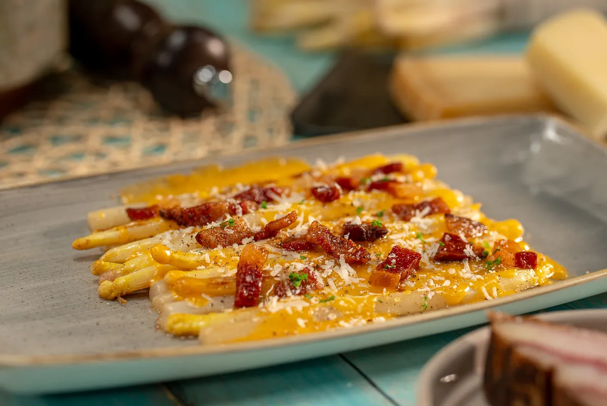 Egy tányéron fehér spárga carbonara szósszal
