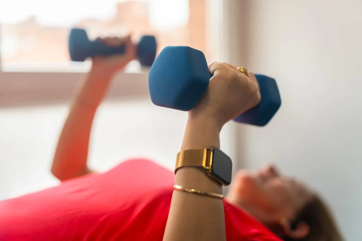 Menopauza idején ajánlott az erőnléti edzés: egy nő fekve súlyzós gyakorlatot végez