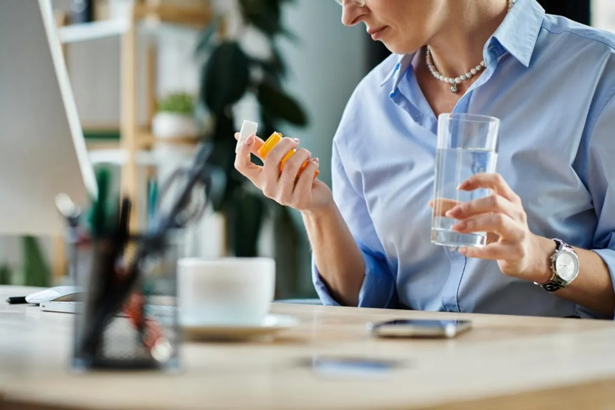 Étrend-kiegészítők menopauzában: egy gyógyszeres cimkét néz egy középkorú nő